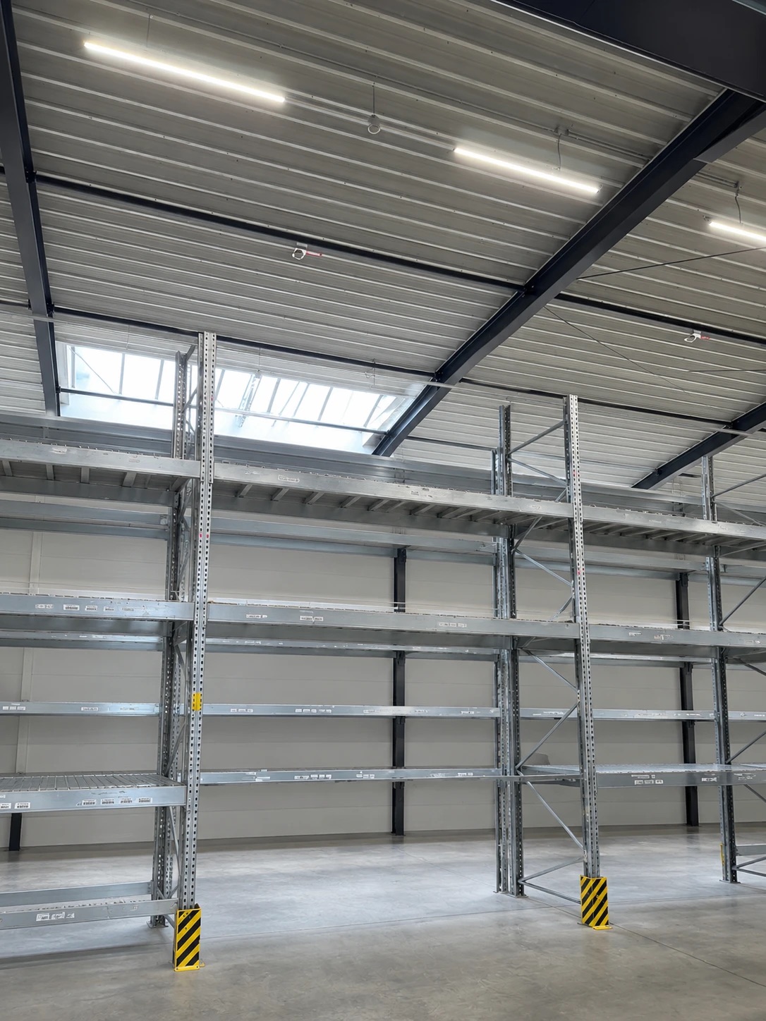 Palettenregale im Lager der lean GmbH in Emsdetten: mehrstöckige Schwerlastregale mit Anfahrschutz in einer hellen Halle